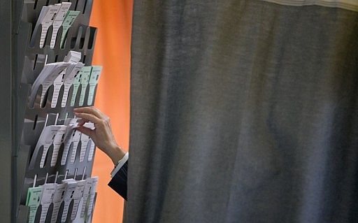  Un ciudadano escoge papeleta antes de ejercer su voto en la urna