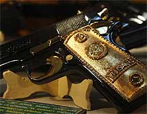 Pistola calibre 0.38 Súper con cachas doradas y el símbolo de Versace. | Efe