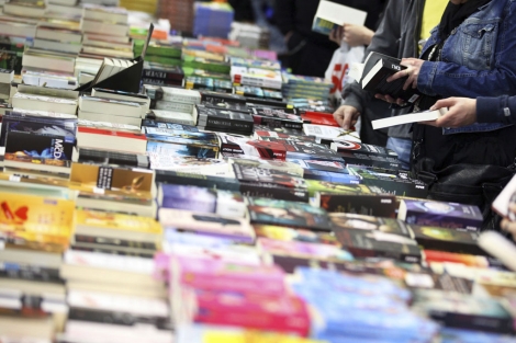 Visitantes buscan libros en una feria. | Efe