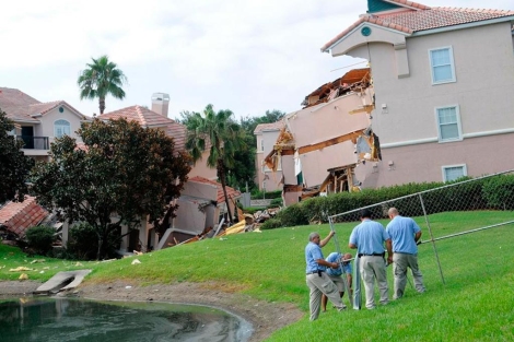 Varios trabajadores del Summer Bay Resort colocan vallas cerca del socavón. | Afp