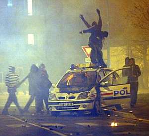 Varios j�venes se suben encima de un coche policial. (Foto: AP)