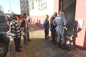Vecinos y policías en el portal del detenido el día después de la desaparición. (Foto: Antonio Luis Delgado)