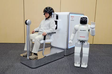 El robot Asimo levanta el brazo izquierdo tras recibir la orden mental de un hombre. | AFP