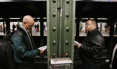 Lectores de libros electrónicos en el Metro de Nueva York. | Reuters