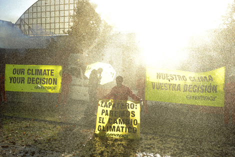 Activistas de Greenpeace han simulado una tormenta a la entrada de la reunión. | Greenpeace. Activistas de Greenpeace han simulado una tormenta a la entrada de la reunión. | Greenpeace.