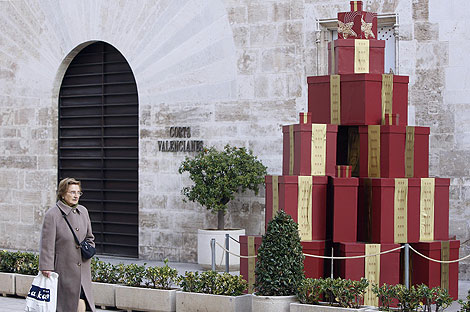 Un &aacute;rbol de Navidad formado por cajas de regalos en la puerta de las Cortes. | B. Pajares