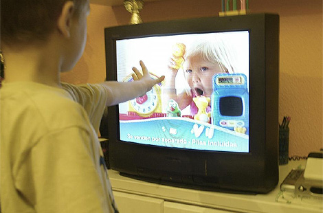 Un ni&ntilde;o, delante de una televisi&oacute;n con publicidad en emisi&oacute;n. (Foto: Julio Palomar)