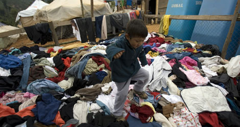 Un niño salta sobre una montaña de ropa donada tras el seísmo. | Efe