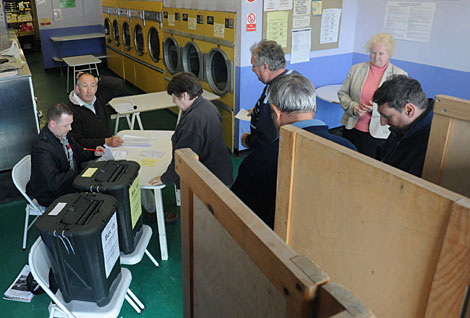 Un grupo de personas deposita su voto en una lavandería de Oxford. | Reuters