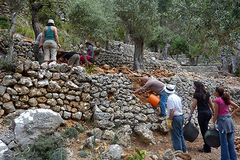 Los voluntarios aprenden y ayudan a reconstruir los muros