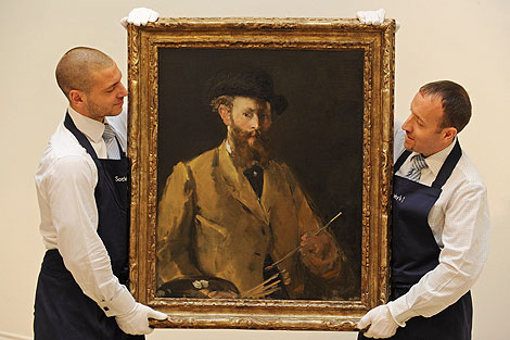 Dos empleados de Sotheby's transportan el cuadro. | Afp