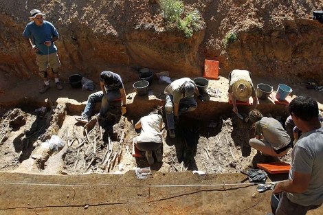 Algunos de los trabajadores que exhuman los restos hallados en la fosa de Burgo. | Afp