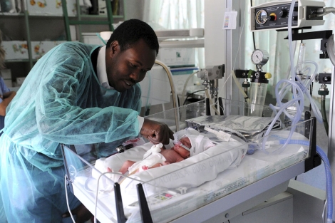 El padre de Edil acaricia la recién nacida en el Hospital Santa Ana de Turín. | Efe