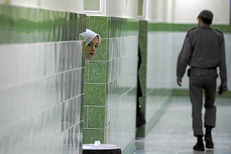 Una presa iraní se asoma mientras un guardia vigila la sección femenina de la cárcel de Evin. | Afp