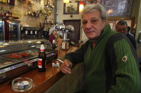Rodrigo Arroyo fuma en la barra de su restaurante tras la entrada en vigor de la ley | Reuters
