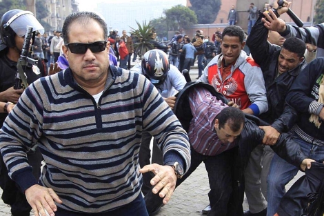 Un policía de civil corre a atacar a un periodista en El Cairo (Foto: Reuters)