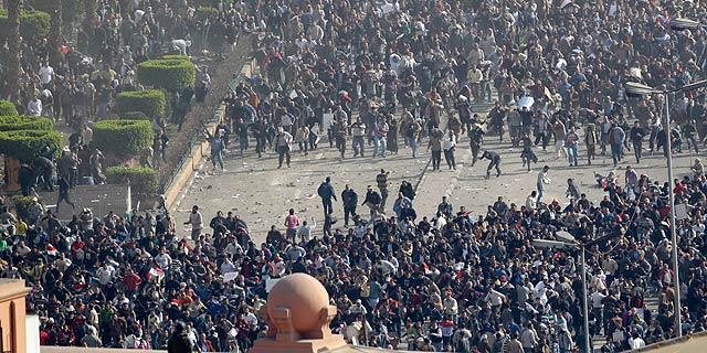 Los defensores de Mubarak (abajo) se enfrentan a los opositores al r&eacute;gimen (arriba) en El Cairo. | Afp | M&Aacute;S IM&Aacute;GENES