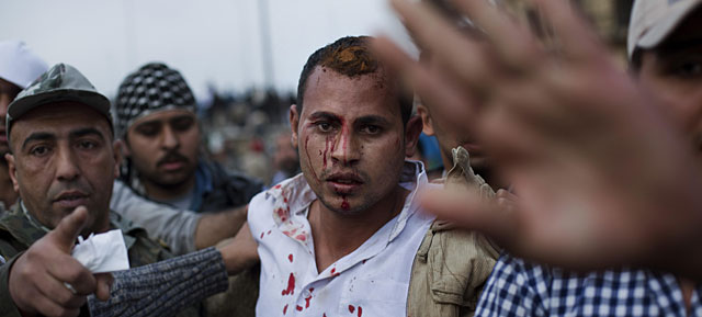 Un hombre sospechoso de ser un policía de paisano, escoltado por manifestantes anti Mubarak. | AP VEA MÁS FOTOS