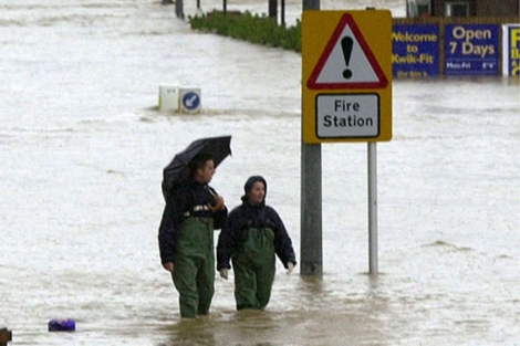 Una pareja camina por una calle inundada del sur de Gran Bretaña en el año 2000.