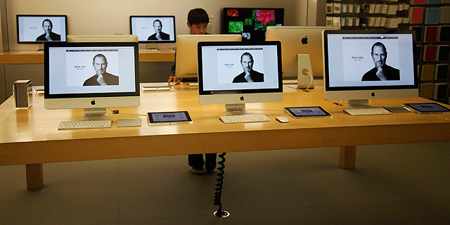 Un niño observa un ordenador con la imagen de Steve Jobs en una tienda Apple de California. | Reuters