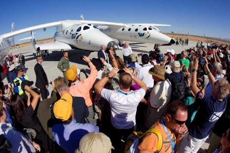 Branson (de blanco) saluda a los asistentes a la presentación del aeropuerto espacial. | AP Branson (de blanco) saluda a los asistentes a la presentación del aeropuerto espacial. | AP