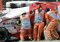 Operarios intentan sacar a Kovalainen del coche. Foto:AP Operarios intentan sacar a Kovalainen del coche. Foto:AP