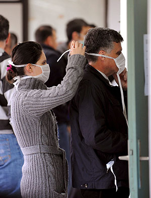 Una mujer coloca una mascarilla a un hombre. (Foto: Georgi Licovski | EFE)