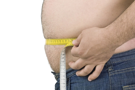 Un varón mide su abdomen con un metro.| El Mundo