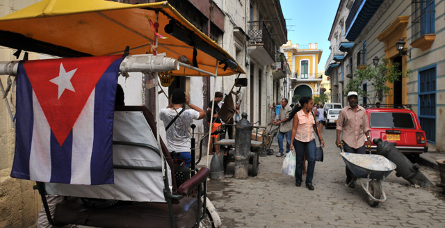 Un hombre empuja una carreta mientras conversa con una mujer en La Habana. | Efe