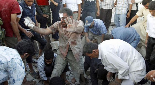 Un hombre gesticula al descubrir un cadáver entre los escombros tras un bombardeo en Azaz. | Reuters